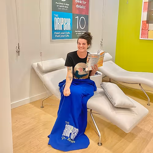 Clients relaxing in comfortable chairs receiving wellness IV therapy in a calm environment.